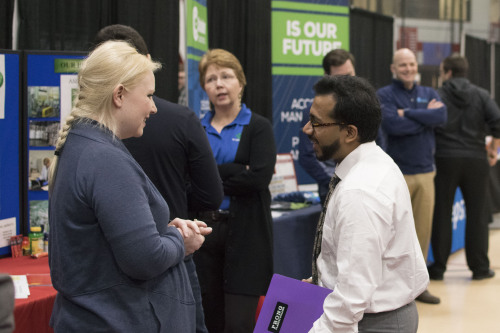 A student talking with a potential employer at a Career Expo.