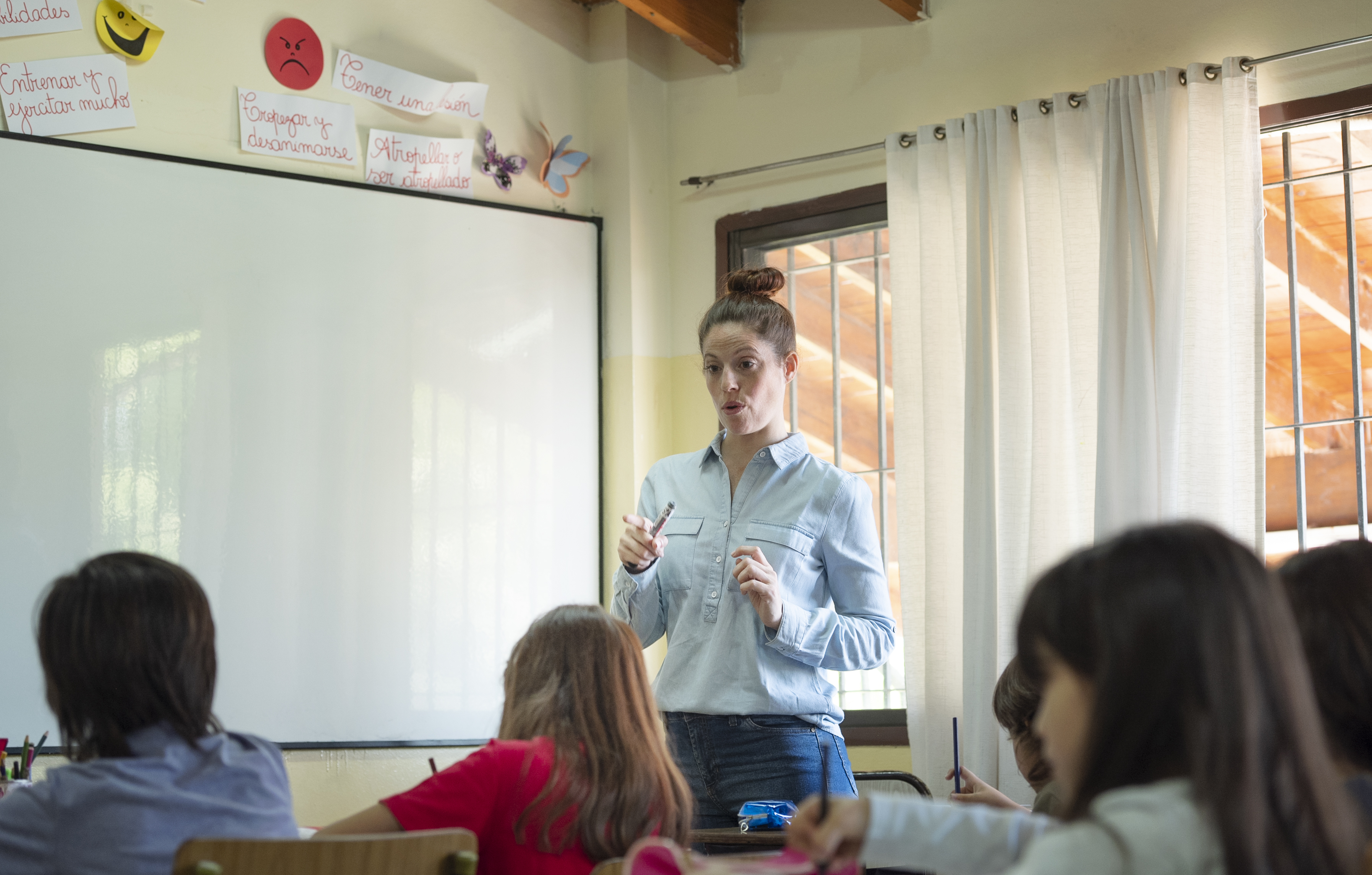 An ESL teacher standing in front of students in a classroom.