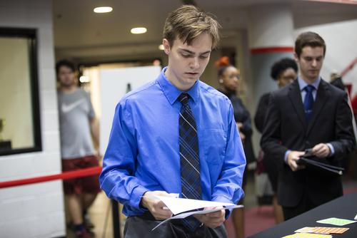 A student looks over a paper while preparing for the career expo