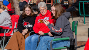 A family watches the Homecoming Parade wearing SEMO gear.