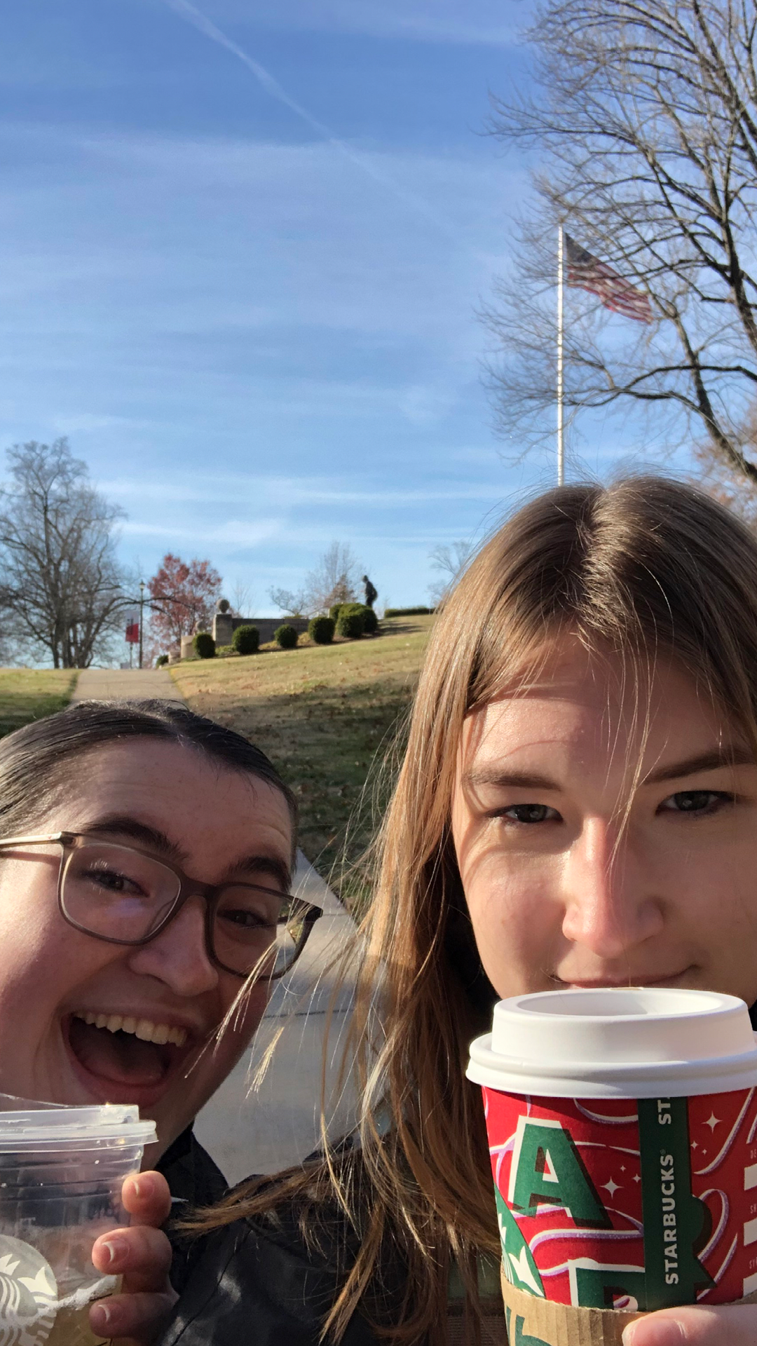 Isabel and a friend taking a selfie holding Starbucks coffee