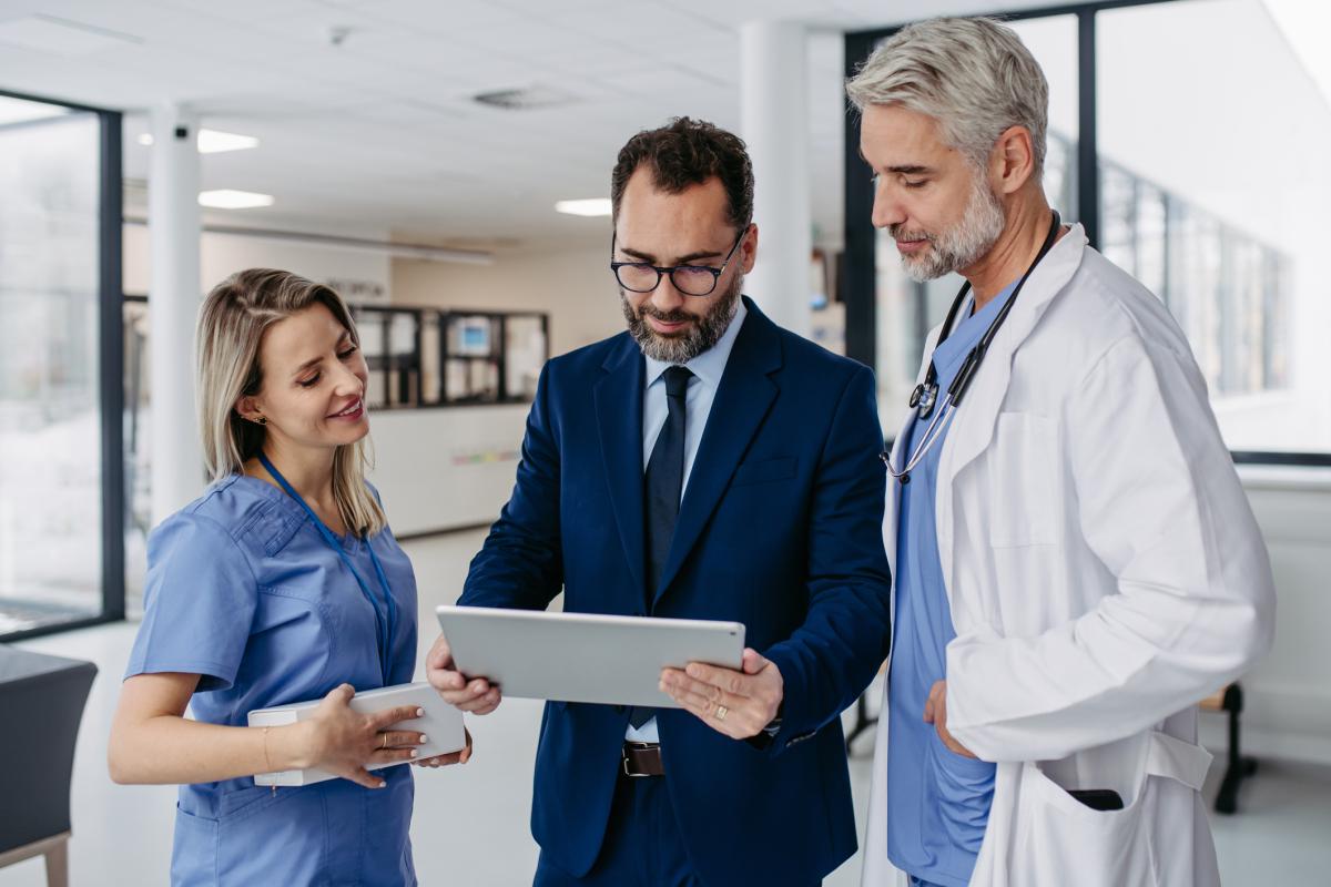 A hospital manager speaks with a nurse and doctor.