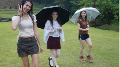 Ellyssa walking with her two friends outside in Korea during a light rain