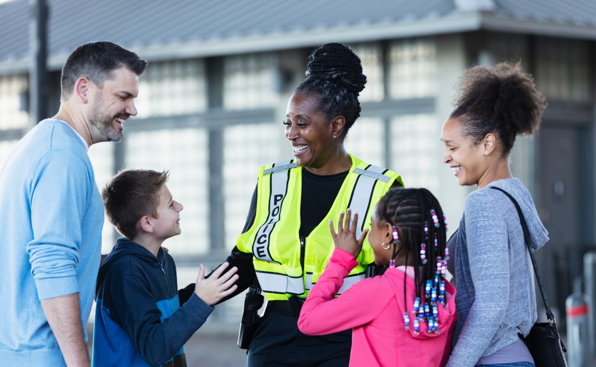 A police officer talks with parents and children outdoors.