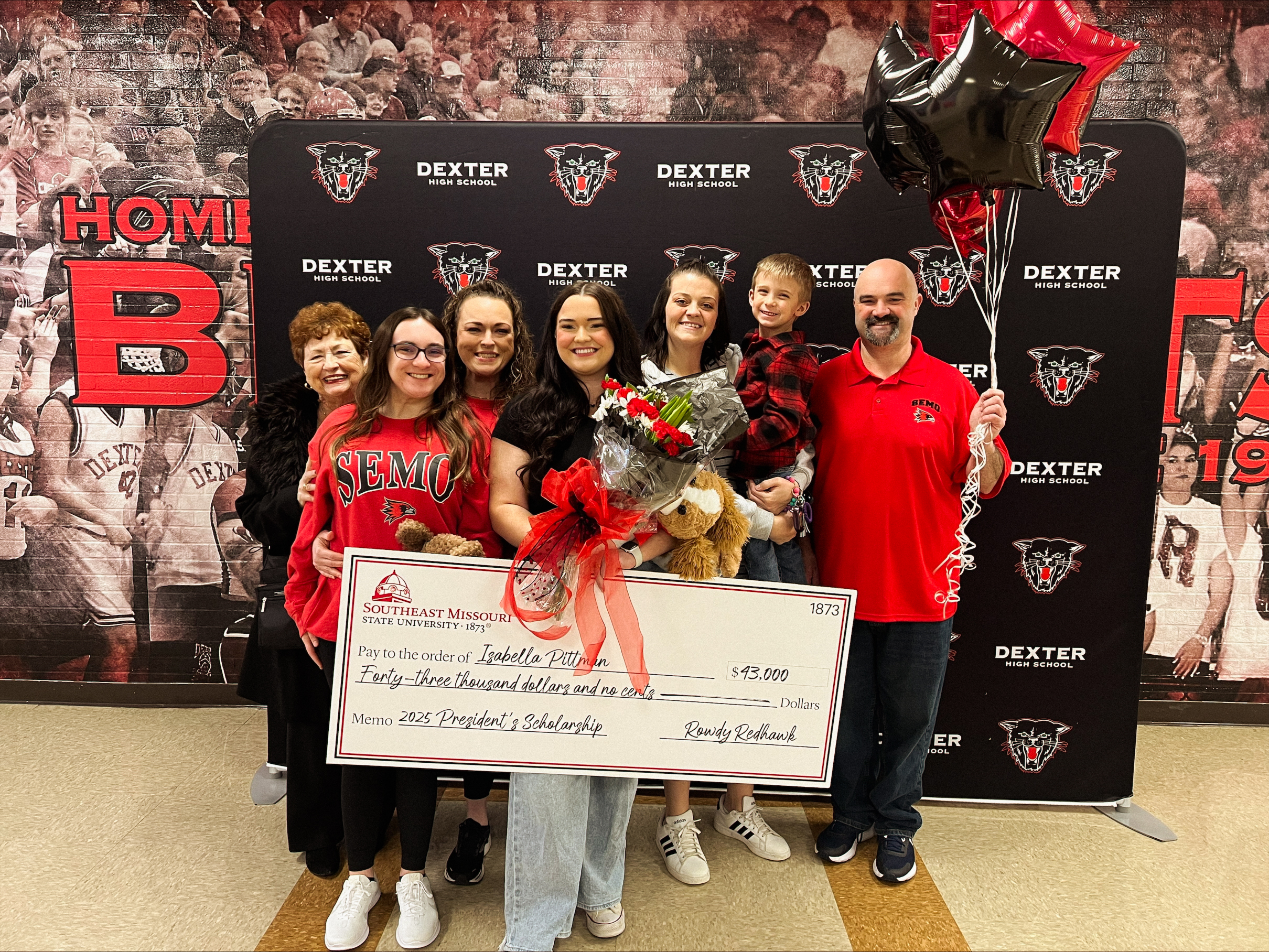 Isabella Pittman receiving a check for $43,000 at Dexter High School with her family, receiving the SEMO Presidents Scholarship.