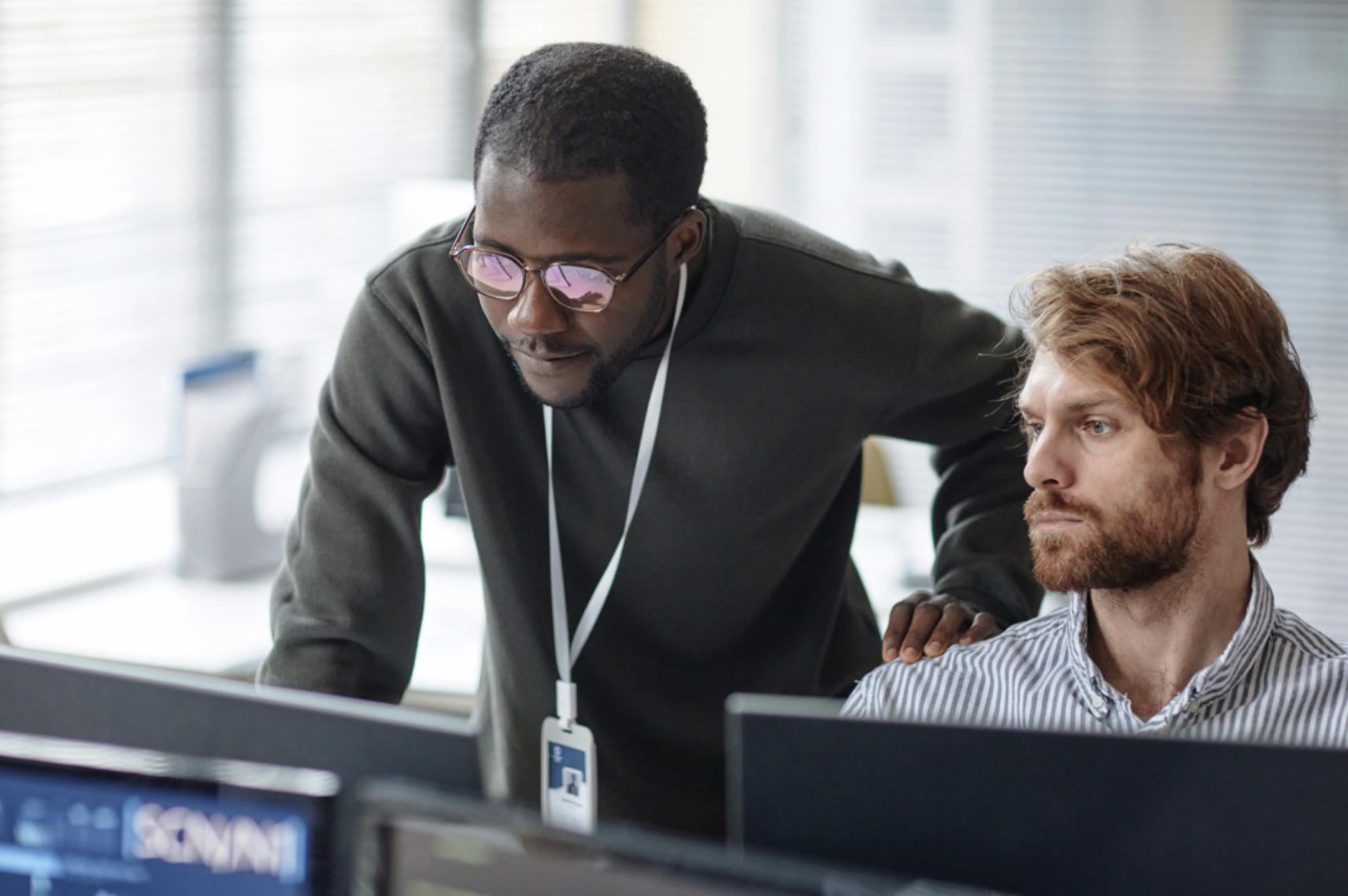 A cybersecurity consultant guides an IT team member through recommended security practices.