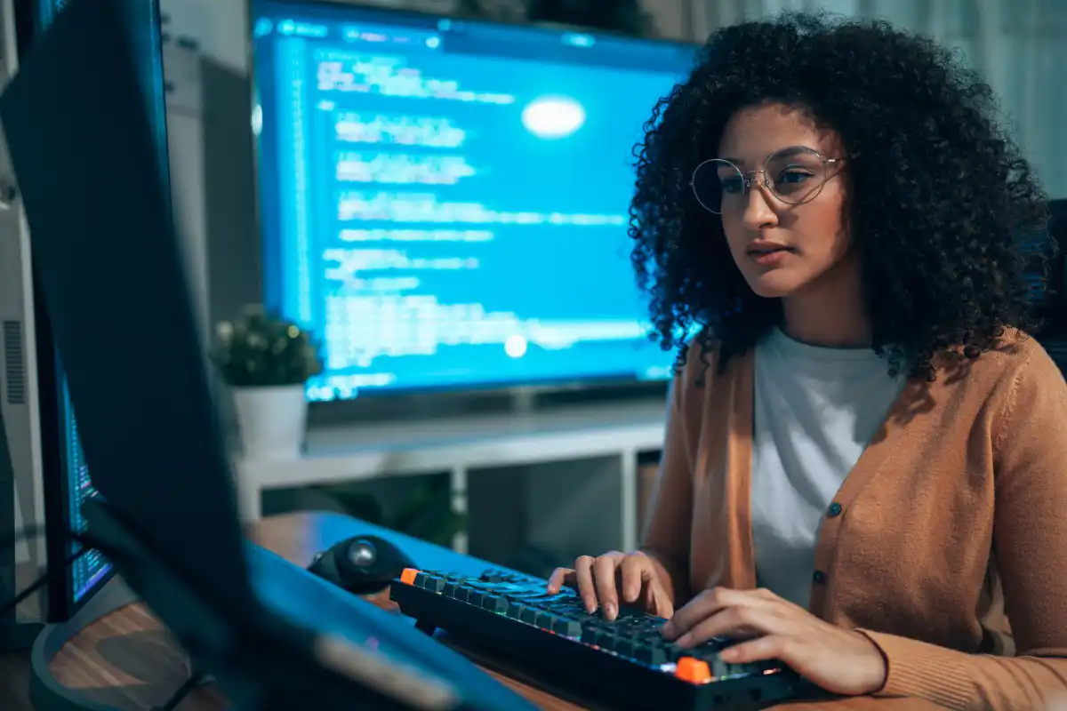 A cybersecurity professional reviews code on a monitor.