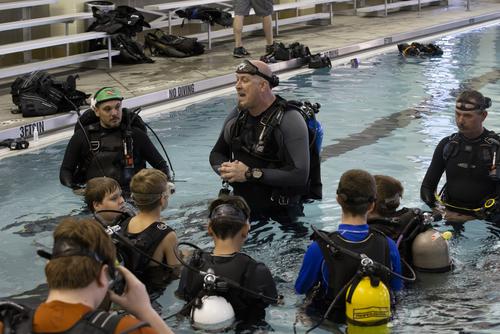 Scouts listen to an instructor in SCUBA gear at the aquatic center at Southeast Missouri State University. 