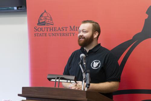 Student Government representative announces an Award during a press conference.