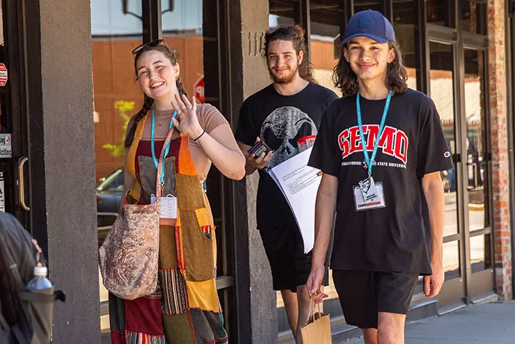 SEMO students participating in Camp Redhawk walk up a downtown Cape Girardeau sidewalk talking and laughing