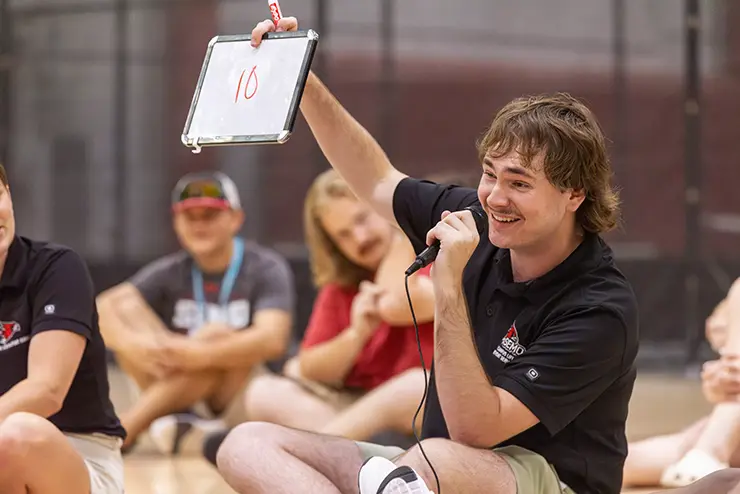a SEMO student sits with a group of others and holds up a board with the number ten written on it