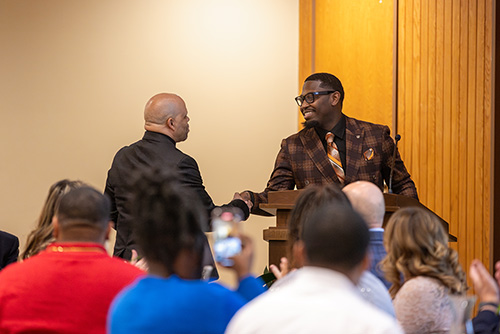 Another dinner speaker takes the podium at the front of the room.