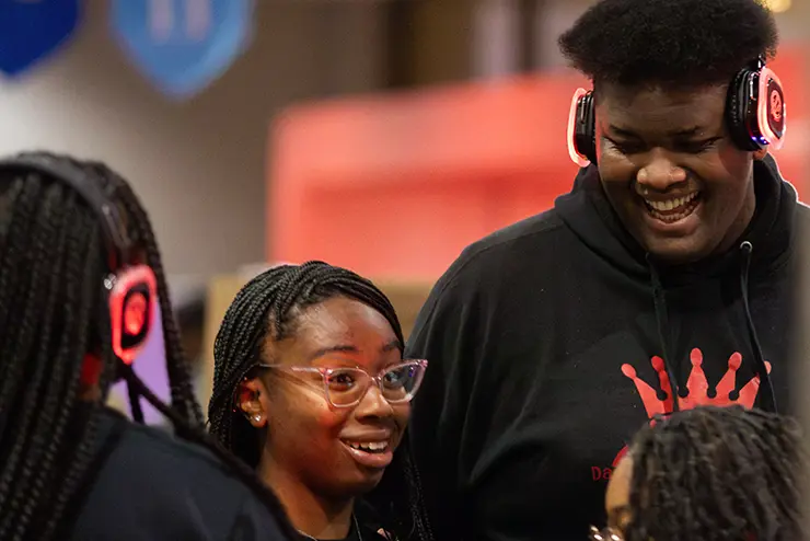 a group of students wearing headphones and talking participate in engagefest