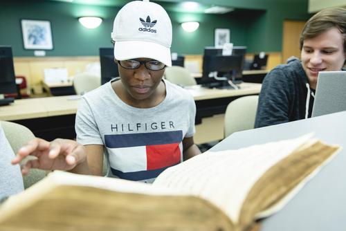 A medieval history student looks at medieval texts in Kent Library.