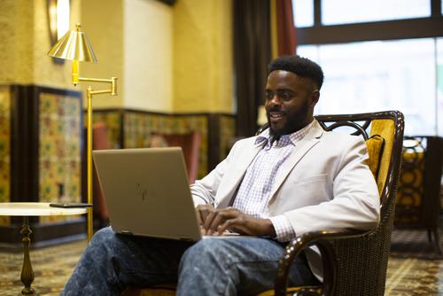 A student sits in a chair to work on their laptop at the Marquette Hotel.