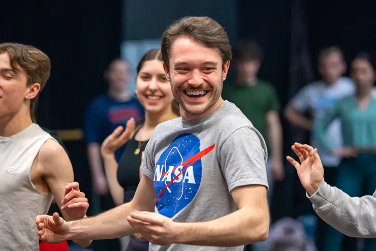 a theatre student laughs and smiles while participating in a training exercise