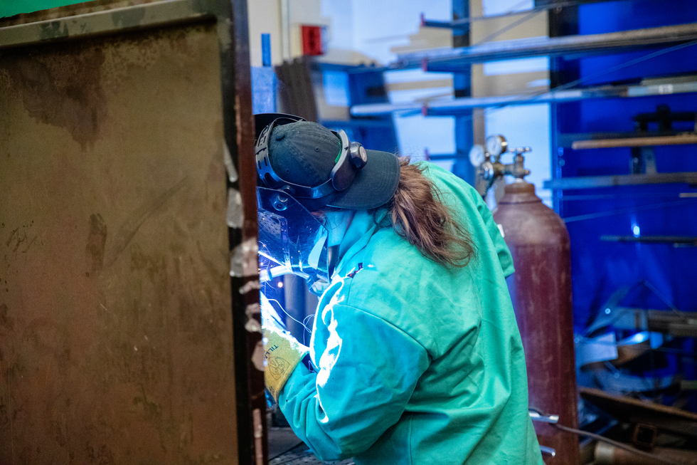 A student welds during a metal sculpting project.