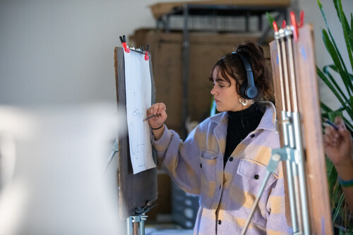 Am art student draws on an easel at SEMO.
