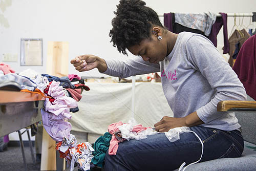 an art and design sculpture student works on her fabric sculpture in a studio