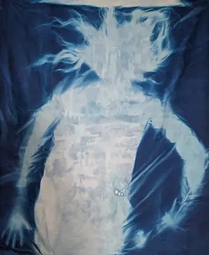 a tie-dyed fabric art piece featuring a white figure against a blue background
