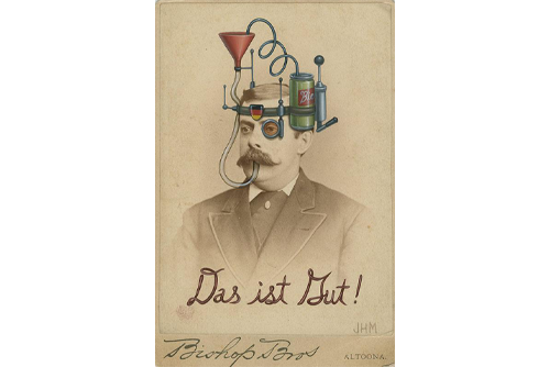 An old-fashioned photo of a man with a device painted on his head that includes a beverage can with a straw running into the man’s mouth. 