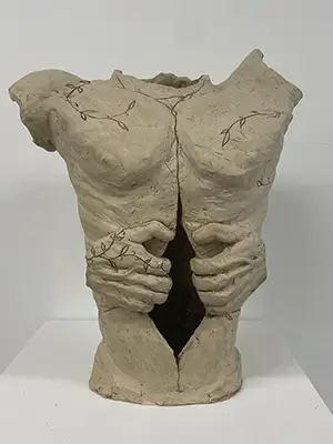 a sculpture done in a gray/brown material that looks like mud - it is a man's torso without arms, but has hands at the waist pulling it open to reveal a dark space inside