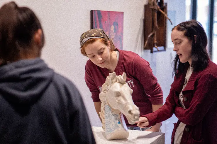 A semo student examines a sculpture in crisp museum showcasing her experienital learning project