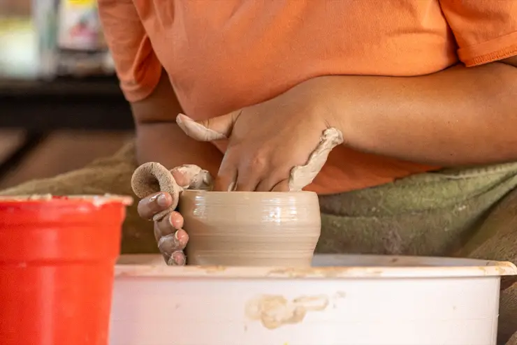 A SEMO student spinning a pot on the pottery wheel during the Innovation Dock at River Campus