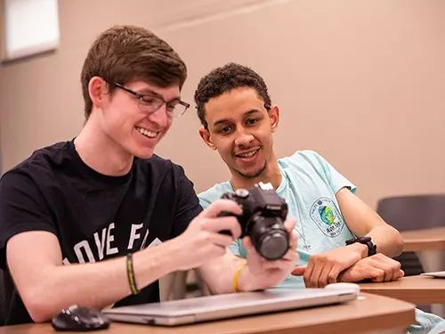 two SEMO mass media, art, and design students look at photo results on a digital camera together