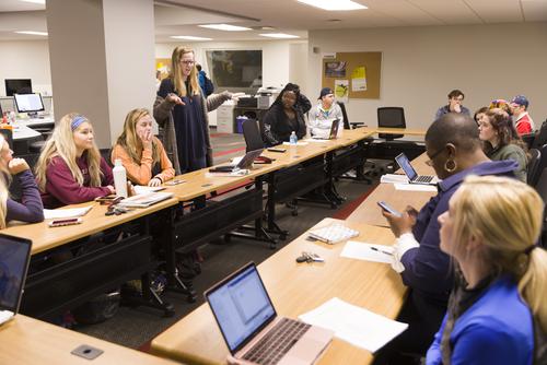 A group of mass media students have a discussion in the lower level of Rust Center for Media.
