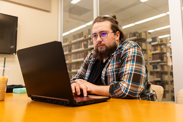 A student works on a laptop in the study rooms in the Kent Library.