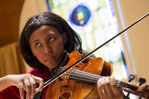 Student plays string instrument during concert performance