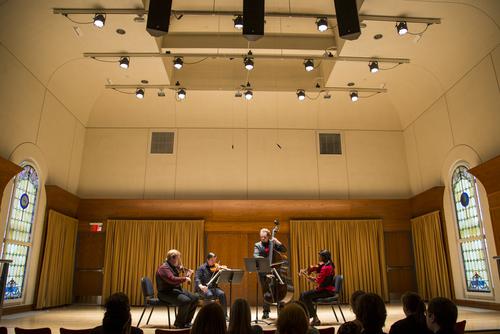 Students perform with string instruments during concert.