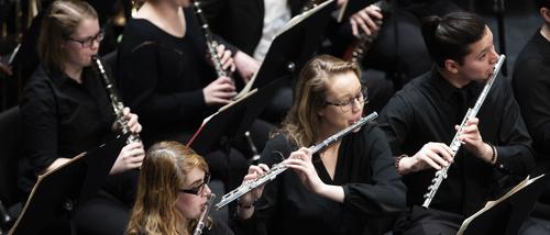 Students play wind instruments during a wind symphony performance