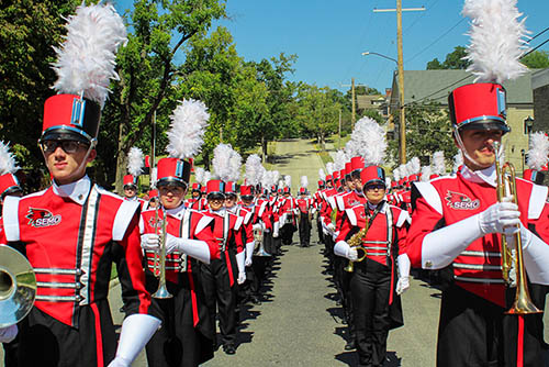 The Southeast Marching Band walks down the street playing their instruments before a football game.