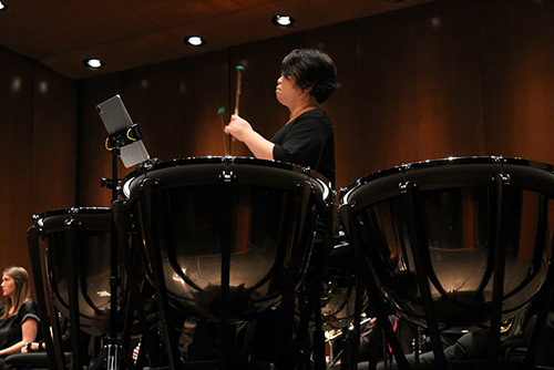  Symphony Orchestra member play drums.  