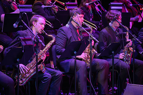 Students play musical instruments in a practice room 