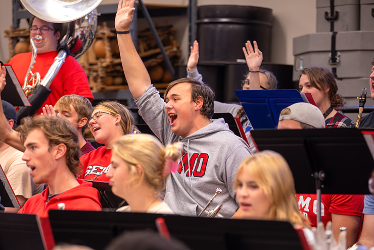 The Show band gather together in a class room.
