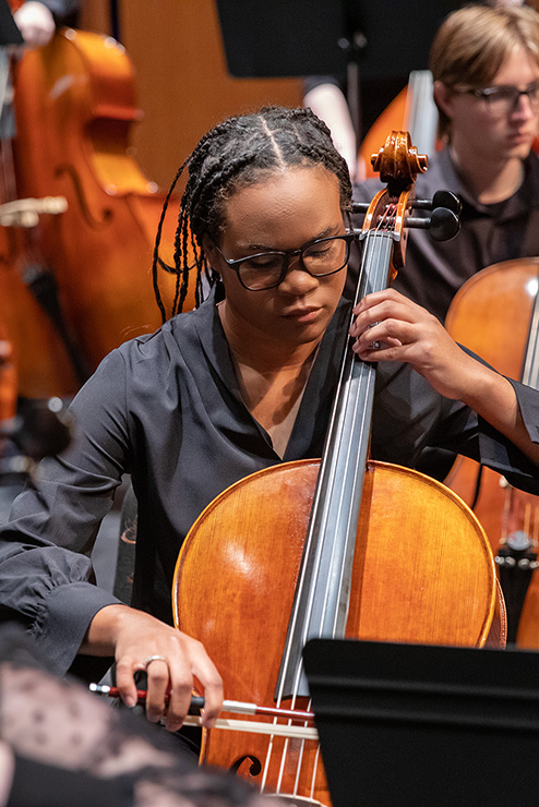 During the symphony orchestra, a student plays the Cello.