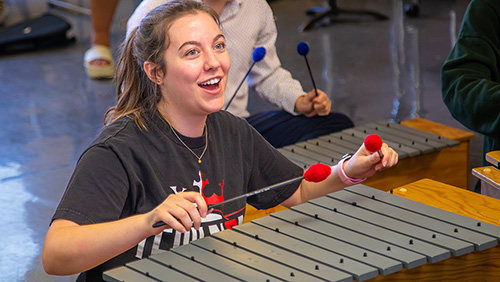 A student playing the xylophone during music class.
