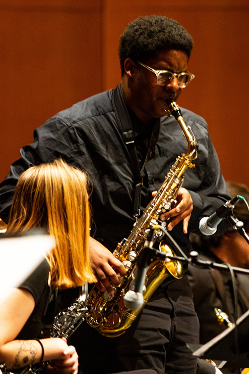 During the Jazz concert, a student plays a tenor saxophone.