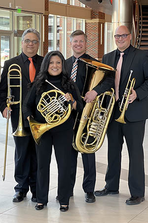 three musicians pose together with each other and their instruments