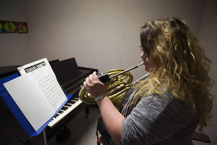a SEMO horn student plays in the practice room at Dobbins