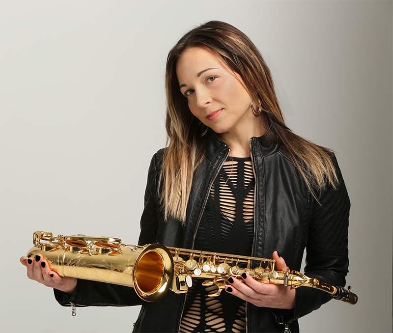 a professional headshot photo of sharel cassity in a leather jacket holding her saxophone