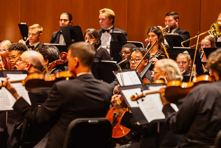 SEMO students wearing dress clothes performing on bedell stage with the symphony orchestra