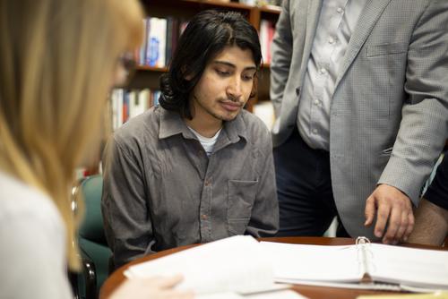 A graduate student reviews documents in class.