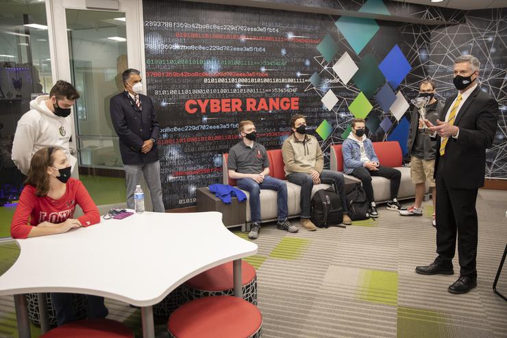 The provost speaks to the Cyber Defense Team in the Cyber Range about a recent achievement.