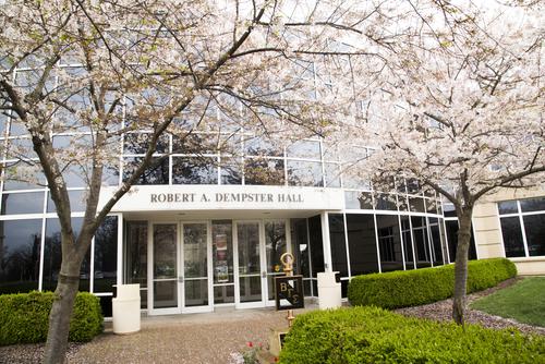 Trees bloom next to an entrance to Dempster Hall.