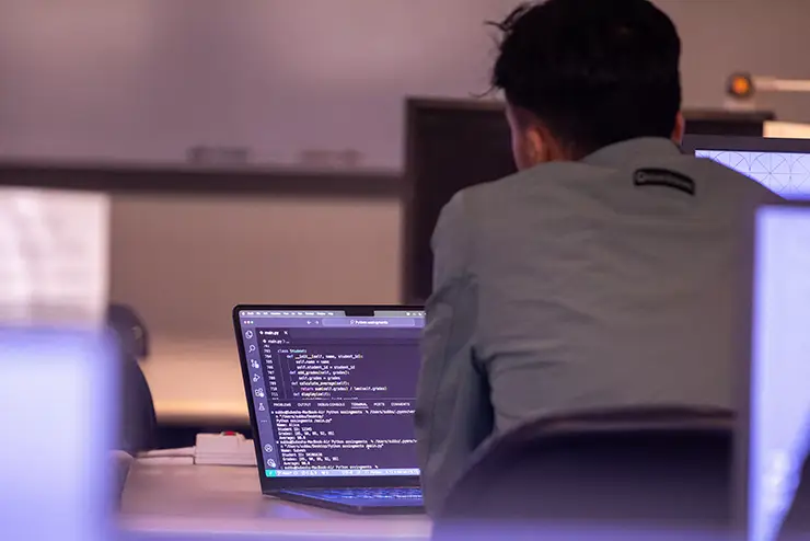 a SEMO cybersecurity student sits at his laptop and works on a python program