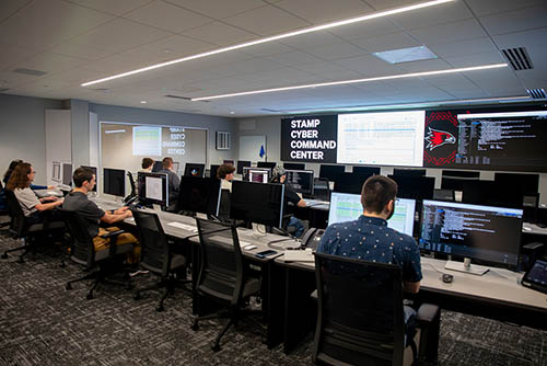 students are seated in the SEMO Cyber Command Center and work on individual computers